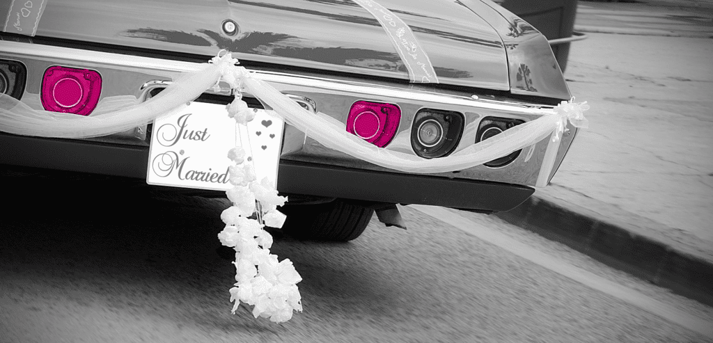 the back of a wedding car with just married sign and ribbons